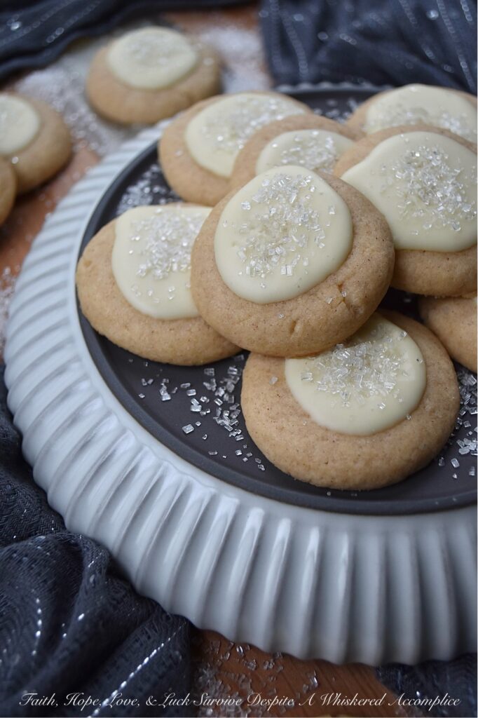 Snowy Eggnog Melt-Away Cookies - One bite of these sweet buttery melt-in-your-mouth cookies, and you'll be transported to a winter wonderland. With their dusting of white sparkling sugar snow, simple eggnog and powdered sugar icing, and warm nutmeg and cinnamon spices, these Snowy Eggnog Melt-Away Cookies are the ideal treat for the chilly holiday season.