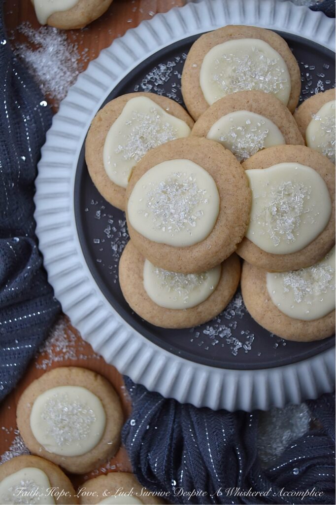 Snowy Eggnog Melt-Away Cookies - One bite of these sweet buttery melt-in-your-mouth cookies, and you'll be transported to a winter wonderland. With their dusting of white sparkling sugar snow, simple eggnog and powdered sugar icing, and warm nutmeg and cinnamon spices, these Snowy Eggnog Melt-Away Cookies are the ideal treat for the chilly holiday season.