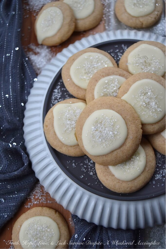 Snowy Eggnog Melt-Away Cookies - One bite of these sweet buttery melt-in-your-mouth cookies, and you'll be transported to a winter wonderland. With their dusting of white sparkling sugar snow, simple eggnog and powdered sugar icing, and warm nutmeg and cinnamon spices, these Snowy Eggnog Melt-Away Cookies are the ideal treat for the chilly holiday season.