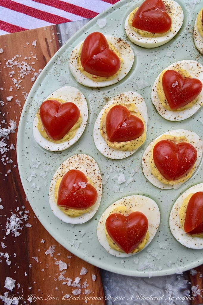 Italian Deviled Eggs with Heart-Shaped Tomatoes - These creamy Italian-seasoned deviled eggs are perfect for weddings, anniversary parties, Galentine's celebrations, Valentine's Day, or as a way to show your loved ones just how much you love them. Topped with a heart-shaped tomato for an added festive touch, these deviled eggs are as gorgeous and whimsical as they are delicious. Their slightly sweet honey and Italian seasoning filling will have everyone falling in love at first bite.