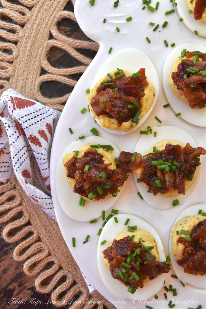 Deviled Eggs with Bourbon & Onion Bacon Jam - Get ready to wow your friends and family with this irresistible deviled egg recipe that is anything but traditional. By adding a sweet, salty, smoky, tangy, and slightly boozy bourbon and onion bacon jam, you can take your deviled eggs to the next level. The combination of rich, salty bacon, sweet yellow onions, smoky chili powder, and a touch of maple syrup and brown sugar creates an over-the-top flavor profile that is sure to impress. And with the addition of onion powder and chives to the egg filling, these deviled eggs are anything but boring with their oniony flavor.