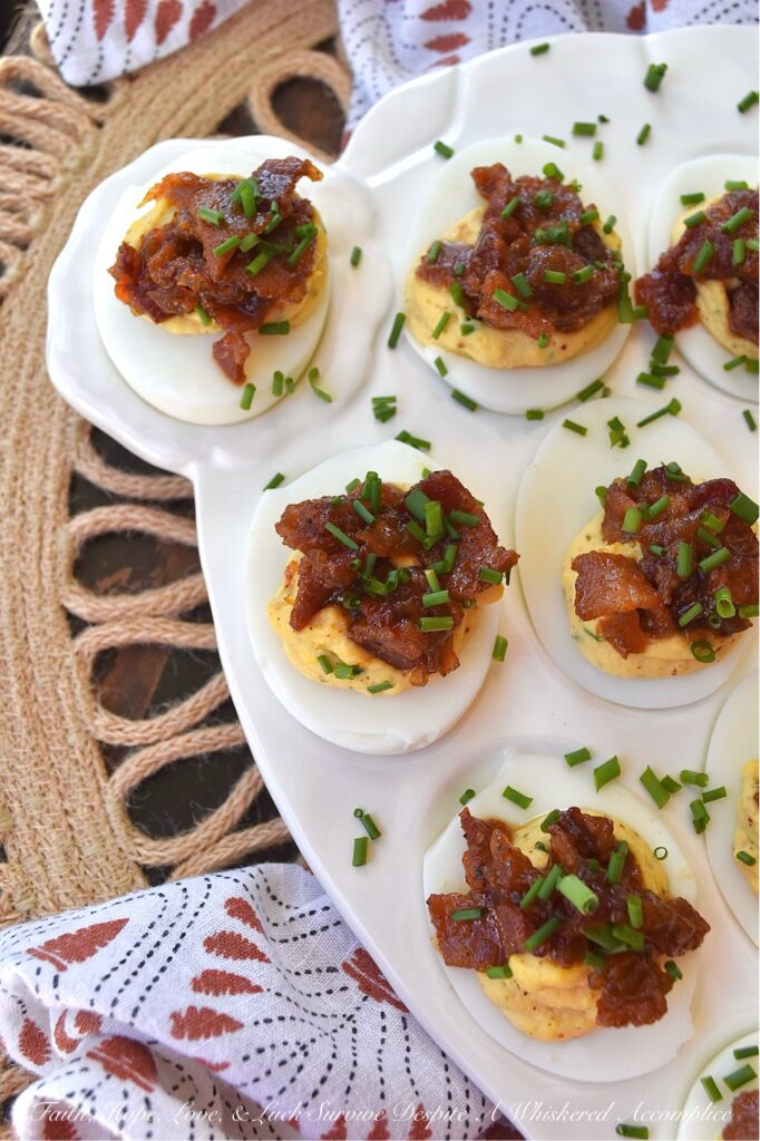 Deviled Eggs with Bourbon & Onion Bacon Jam - Get ready to wow your friends and family with this irresistible deviled egg recipe that is anything but traditional. By adding a sweet, salty, smoky, tangy, and slightly boozy bourbon and onion bacon jam, you can take your deviled eggs to the next level. The combination of rich, salty bacon, sweet yellow onions, smoky chili powder, and a touch of maple syrup and brown sugar creates an over-the-top flavor profile that is sure to impress. And with the addition of onion powder and chives to the egg filling, these deviled eggs are anything but boring with their oniony flavor.