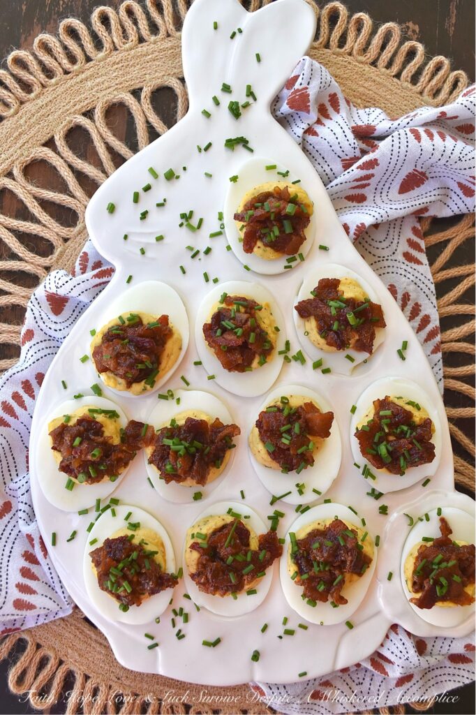 Deviled Eggs with Bourbon & Onion Bacon Jam - Get ready to wow your friends and family with this irresistible deviled egg recipe that is anything but traditional. By adding a sweet, salty, smoky, tangy, and slightly boozy bourbon and onion bacon jam, you can take your deviled eggs to the next level. The combination of rich, salty bacon, sweet yellow onions, smoky chili powder, and a touch of maple syrup and brown sugar creates an over-the-top flavor profile that is sure to impress. And with the addition of onion powder and chives to the egg filling, these deviled eggs are anything but boring with their oniony flavor.