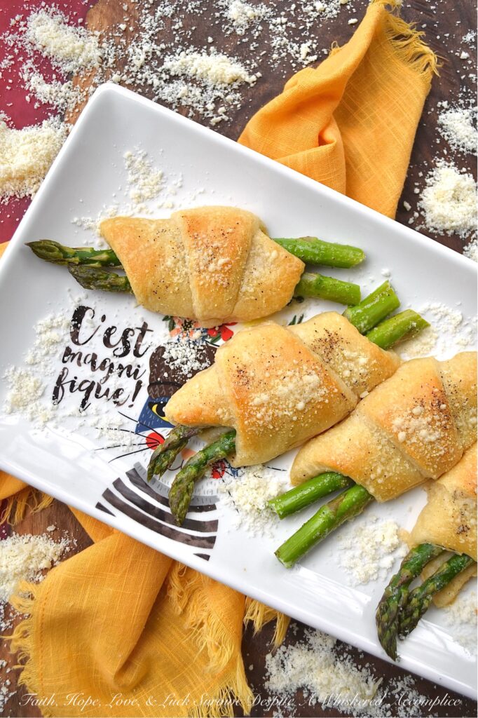 Crescent Wrapped Asparagus with Parmesan - This easy-t0-make recipe combines the fresh, crisp flavor of asparagus with the flaky, buttery goodness of a store-bought refrigerated crescent roll pastry and the slightly salty, cheesy, and nutty flavor of parmesan cheese. Whether enjoyed for breakfast alongside eggs or as a tasty accompaniment to a soup or salad for dinner, these Crescent Wrapped Asparagus with Parmesan are sure to be a hit.