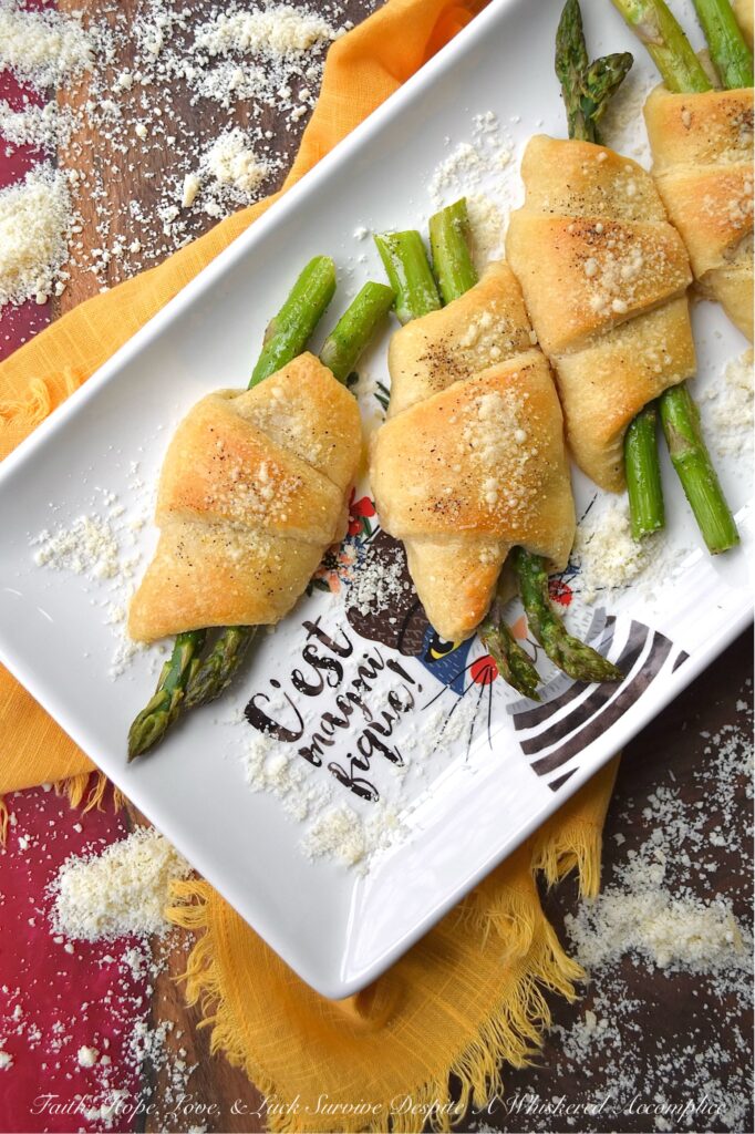 Crescent Wrapped Asparagus with Parmesan - This easy-t0-make recipe combines the fresh, crisp flavor of asparagus with the flaky, buttery goodness of a store-bought refrigerated crescent roll pastry and the slightly salty, cheesy, and nutty flavor of parmesan cheese. Whether enjoyed for breakfast alongside eggs or as a tasty accompaniment to a soup or salad for dinner, these Crescent Wrapped Asparagus with Parmesan are sure to be a hit.