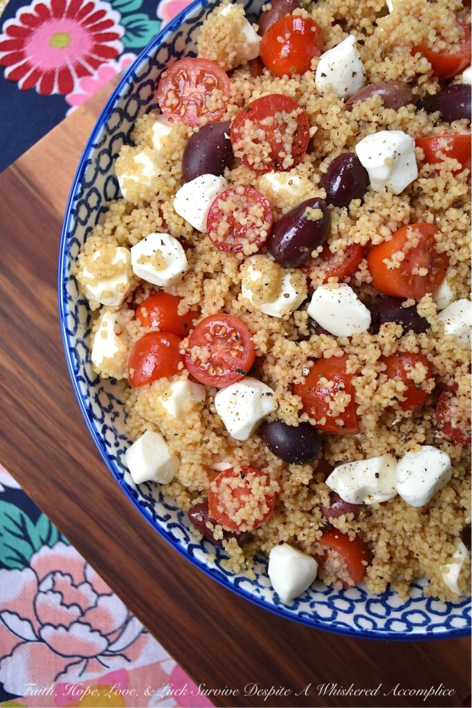 Kalamata, Mozzarella, & Tomato Couscous Salad - Looking for an easy and satisfying pasta side dish? Try this fluffy wheat couscous salad with tangy Kalamata olives, juicy cherry or grape tomatoes, and creamy fresh mozzarella pearls. With minimal time and effort, you can create a substantial pasta salad that is perfect for any occasion. Plus, it's easy to stretch out to serve larger crowds by simply adding fresh vegetables or Italian deli meat to the mix.
