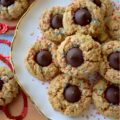 Firecracker Oatmeal Peanut Butter Blossoms - With their combination of creamy peanut butter and chocolatey Hershey's Kisses, these patriotic oatmeal peanut butter blossoms will almost surely cause a summer flavor explosion. These delightful blossom cookies are adorned with a festive and vibrant firecracker-inspired sprinkle of decorative red, white, and blue sugar, making them the perfect addition to any mid-summer celebration or 4th of July gathering.