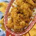 Baked Chicken Tenders with Crushed Fritos - Easy to prepare and perfect for any occasion, these Mexican-inspired baked chicken tenders are sure to be a hit with both kids and adults alike. After being coated in a creamy blend of mayonnaise and zesty taco seasoning, and then covered with a generous layer of crunchy, salty crushed Fritos corn chips, these oven-baked chicken tenders are juicy, perfectly seasoned, and ready to be served as a comforting weeknight meal or a crowd-favorite game day snack.