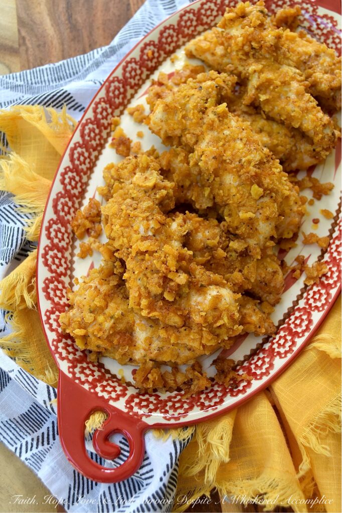 Baked Chicken Tenders with Crushed Fritos - Easy to prepare and perfect for any occasion, these Mexican-inspired baked chicken tenders are sure to be a hit with both kids and adults alike. After being coated in a creamy blend of mayonnaise and zesty taco seasoning, and then covered with a generous layer of crunchy, salty crushed Fritos corn chips, these oven-baked chicken tenders are juicy, perfectly seasoned, and ready to be served as a comforting weeknight meal or a crowd-favorite game day snack.