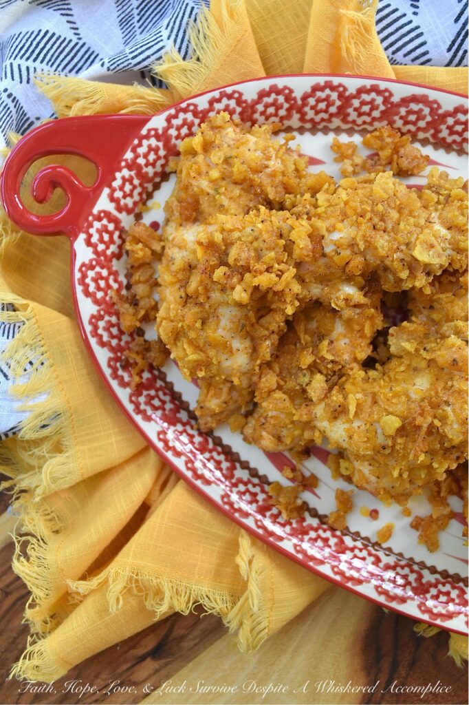 Baked Chicken Tenders with Crushed Fritos - Easy to prepare and perfect for any occasion, these Mexican-inspired baked chicken tenders are sure to be a hit with both kids and adults alike. After being coated in a creamy blend of mayonnaise and zesty taco seasoning, and then covered with a generous layer of crunchy, salty crushed Fritos corn chips, these oven-baked chicken tenders are juicy, perfectly seasoned, and ready to be served as a comforting weeknight meal or a crowd-favorite game day snack.