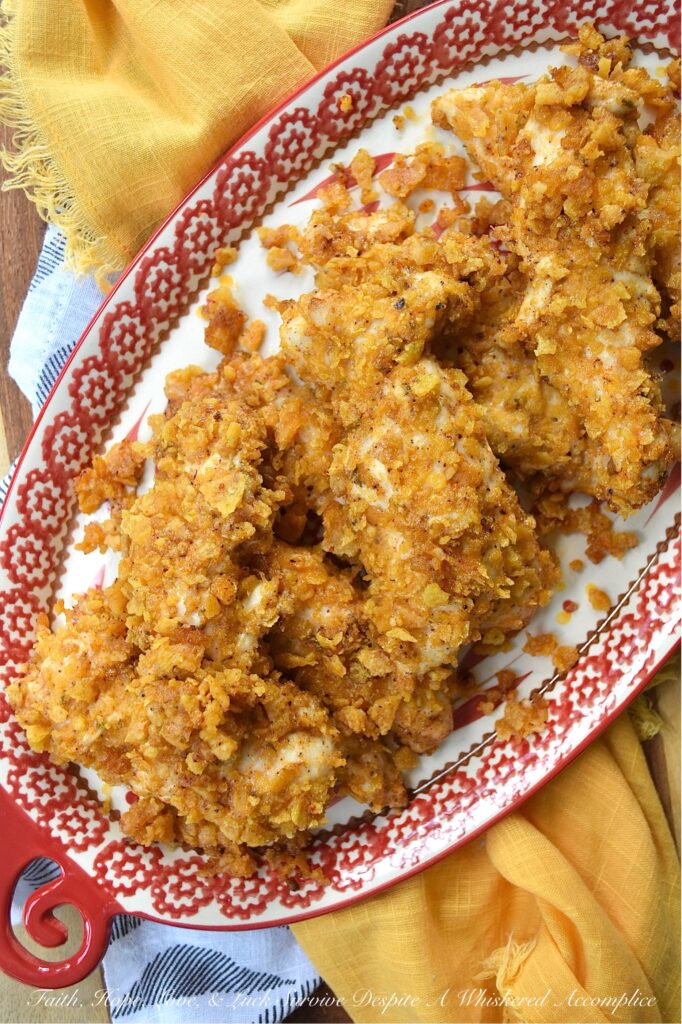 Baked Chicken Tenders with Crushed Fritos - Easy to prepare and perfect for any occasion, these Mexican-inspired baked chicken tenders are sure to be a hit with both kids and adults alike. After being coated in a creamy blend of mayonnaise and zesty taco seasoning, and then covered with a generous layer of crunchy, salty crushed Fritos corn chips, these oven-baked chicken tenders are juicy, perfectly seasoned, and ready to be served as a comforting weeknight meal or a crowd-favorite game day snack.