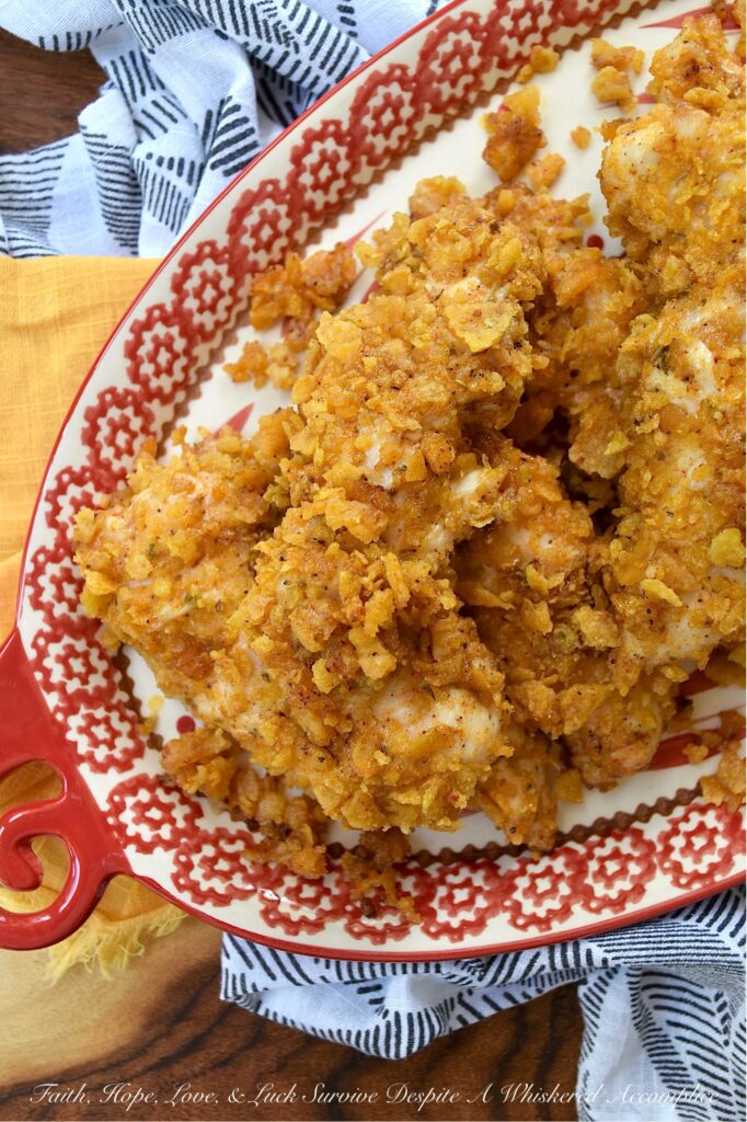 Baked Chicken Tenders with Crushed Fritos - Easy to prepare and perfect for any occasion, these Mexican-inspired baked chicken tenders are sure to be a hit with both kids and adults alike. After being coated in a creamy blend of mayonnaise and zesty taco seasoning, and then covered with a generous layer of crunchy, salty crushed Fritos corn chips, these oven-baked chicken tenders are juicy, perfectly seasoned, and ready to be served as a comforting weeknight meal or a crowd-favorite game day snack.