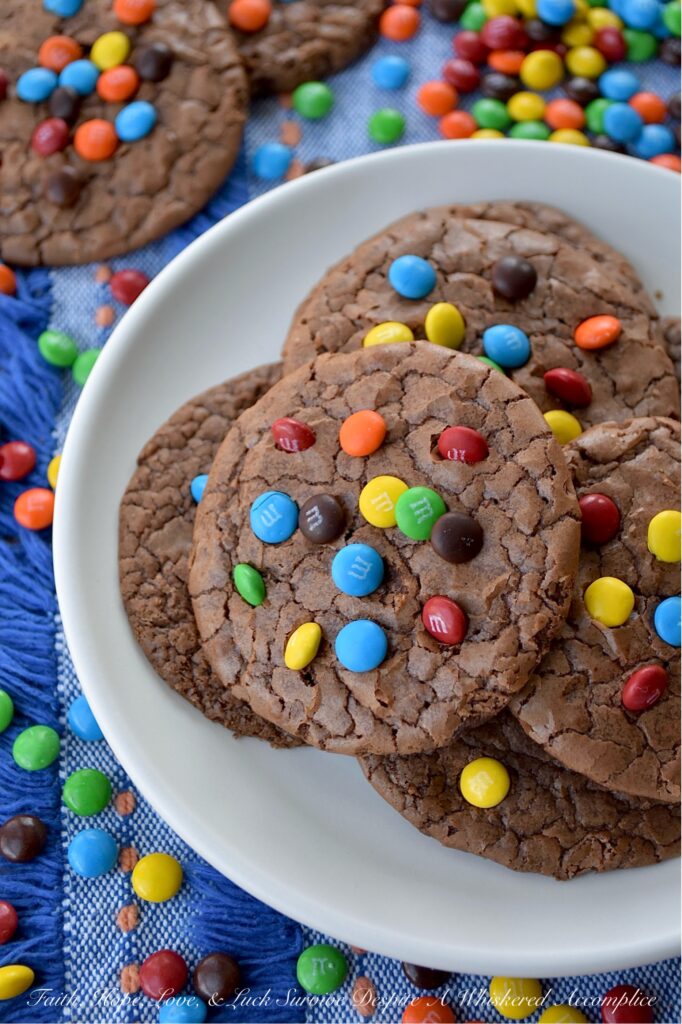 Chocolate Espresso Rainbow Brownie Cookies - Who says you have to choose between cookies and brownies when it’s time for dessert? These super-chocolatey cookies are thin, chewy, and oh-so-delicious, with a glossy, crackled finish that reminds you of your favorite brownies. A hint of espresso perfectly complements the rich chocolate cookie flavor, while vibrant Milk Chocolate M&M's Minis candies add a cheerful pop of rainbow color.