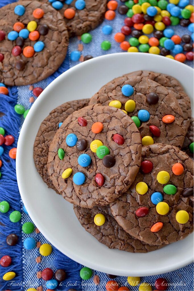 Chocolate Espresso Rainbow Brownie Cookies - Who says you have to choose between cookies and brownies when it’s time for dessert? These super-chocolatey cookies are thin, chewy, and oh-so-delicious, with a glossy, crackled finish that reminds you of your favorite brownies. A hint of espresso perfectly complements the rich chocolate cookie flavor, while vibrant Milk Chocolate M&M's Minis candies add a cheerful pop of rainbow color.