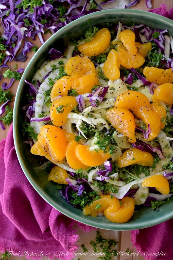 Mandarin Orange & Fennel Mardi Gras Slaw - Get ready to let the good times roll with this vibrant and delicious Mardi Gras-inspired slaw. Crisp purple cabbage, refreshing green fennel and parsley, and not-to-sweet golden mandarin oranges combine to create a visually stunning vegetable side dish with the iconic purple, green, and gold hues of Mardi Gras. Dressed with a simple yet delightful poppy seed dressing, this colorful slaw is the perfect side dish whether you're celebrating Mardi Gras or simply craving a healthy and delicious side dish any day of the year.