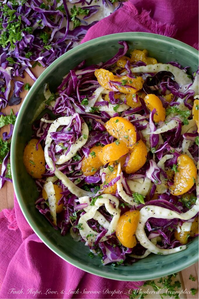 Mandarin Orange & Fennel Mardi Gras Slaw - Get ready to let the good times roll with this vibrant and delicious Mardi Gras-inspired slaw. Crisp purple cabbage, refreshing green fennel and parsley, and not-to-sweet golden mandarin oranges combine to create a visually stunning vegetable side dish with the iconic purple, green, and gold hues of Mardi Gras. Dressed with a simple yet delightful poppy seed dressing, this colorful slaw is the perfect side dish whether you're celebrating Mardi Gras or simply craving a healthy and delicious side dish any day of the year.