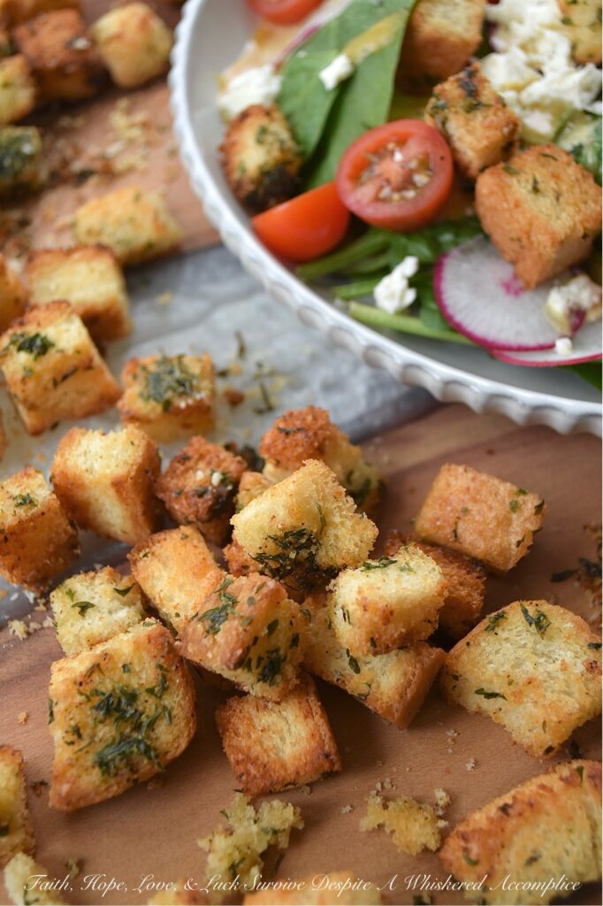 Baked Homemade Buttery Herb Croutons - Tired of the same old salads? These incredibly delicious, homemade baked croutons are buttery and flavorful while adding the perfect crunch to almost any salad. After being cubed and tossed with an herb-infused savory butter mixture, white sandwich bread is baked to golden brown crunchy toasted crouton perfection. With these irresistible homemade croutons, you'll discover there's no such thing as a boring salad.