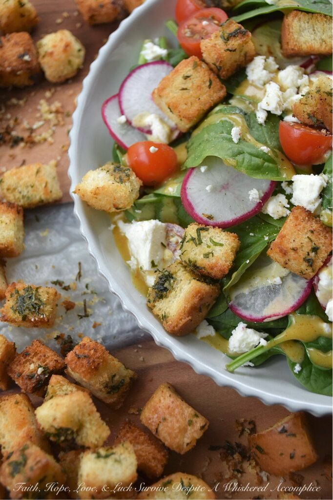 Baked Homemade Buttery Herb Croutons - Tired of the same old salads? These incredibly delicious, homemade baked croutons are buttery and flavorful while adding the perfect crunch to almost any salad. After being cubed and tossed with an herb-infused savory butter mixture, white sandwich bread is baked to golden brown crunchy toasted crouton perfection. With these irresistible homemade croutons, you'll discover there's no such thing as a boring salad.