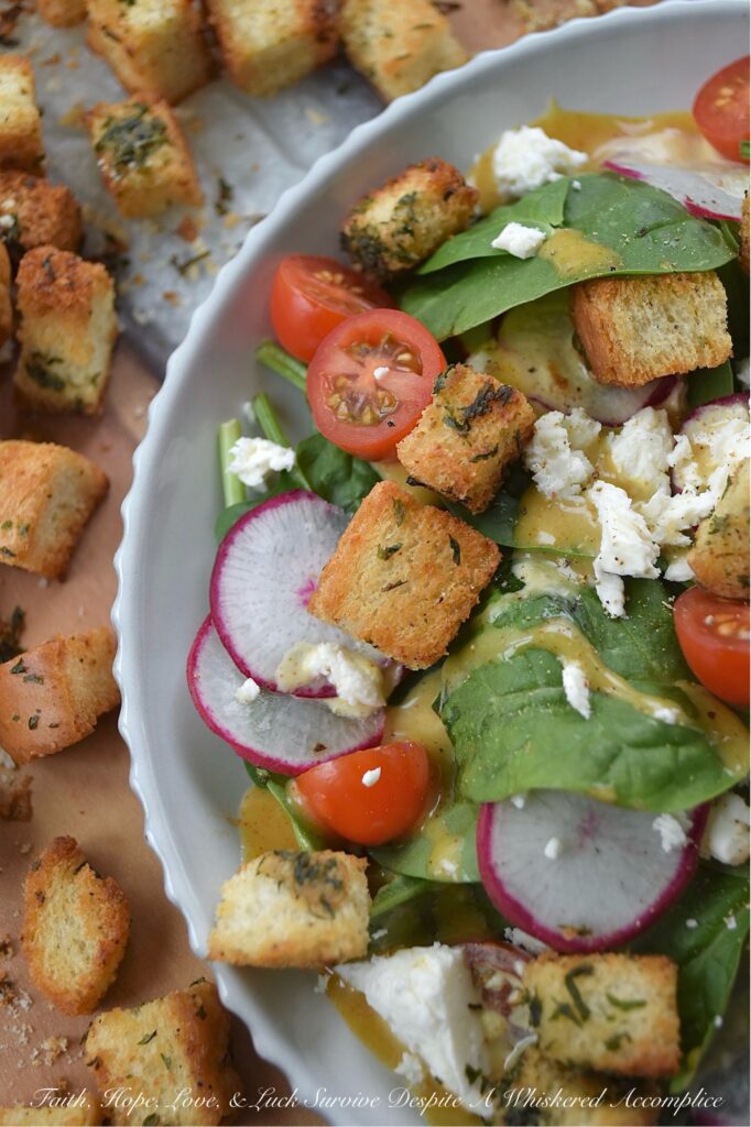Baked Homemade Buttery Herb Croutons - Tired of the same old salads? These incredibly delicious, homemade baked croutons are buttery and flavorful while adding the perfect crunch to almost any salad. After being cubed and tossed with an herb-infused savory butter mixture, white sandwich bread is baked to golden brown crunchy toasted crouton perfection. With these irresistible homemade croutons, you'll discover there's no such thing as a boring salad.