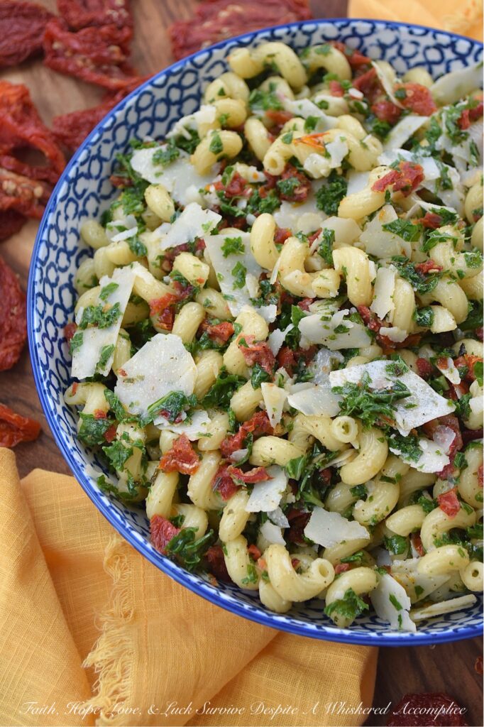 Sun-Dried Tomato & Kale Italian Pasta Salad - Don't let the kale in this homemade pasta salad scare you off. Its subtle, earthy flavor blends seamlessly into the salad while adding a pop of vibrant green color and a nutritional boost, which, in this simple salad, transforms the often-overlooked and disliked leafy green into a surprisingly delicious star ingredient. This vibrant and flavorful side dish features perfectly cooked spiral pasta tossed in a zesty Italian herb dressing, along with the addition of nutty parmesan cheese and the intense sweet flavor of sun-dried tomatoes. It's a guaranteed healthy crowd-pleaser, perfect for potlucks, picnics, or even as a weeknight meal.