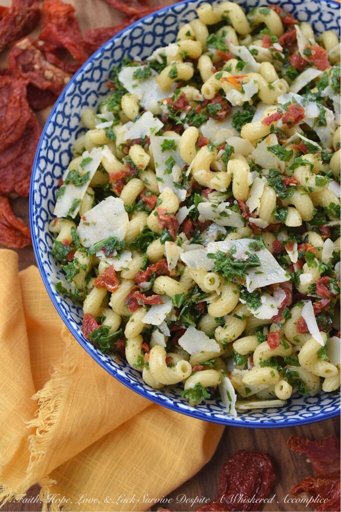 Sun-Dried Tomato & Kale Italian Pasta Salad - Don't let the kale in this homemade pasta salad scare you off. Its subtle, earthy flavor blends seamlessly into the salad while adding a pop of vibrant green color and a nutritional boost, which, in this simple salad, transforms the often-overlooked and disliked leafy green into a surprisingly delicious star ingredient. This vibrant and flavorful side dish features perfectly cooked spiral pasta tossed in a zesty Italian herb dressing, along with the addition of nutty parmesan cheese and the intense sweet flavor of sun-dried tomatoes. It's a guaranteed healthy crowd-pleaser, perfect for potlucks, picnics, or even as a weeknight meal.