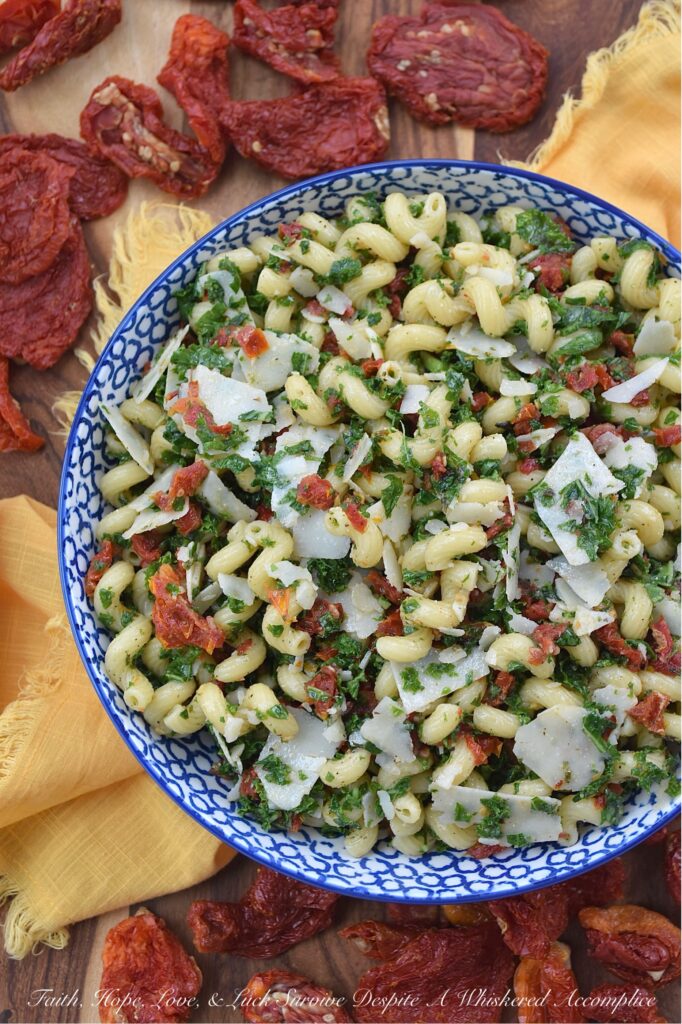 Sun-Dried Tomato & Kale Italian Pasta Salad - Don't let the kale in this homemade pasta salad scare you off. Its subtle, earthy flavor blends seamlessly into the salad while adding a pop of vibrant green color and a nutritional boost, which, in this simple salad, transforms the often-overlooked and disliked leafy green into a surprisingly delicious star ingredient. This vibrant and flavorful side dish features perfectly cooked spiral pasta tossed in a zesty Italian herb dressing, along with the addition of nutty parmesan cheese and the intense sweet flavor of sun-dried tomatoes. It's a guaranteed healthy crowd-pleaser, perfect for potlucks, picnics, or even as a weeknight meal.