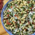 Sun-Dried Tomato & Kale Italian Pasta Salad - Don't let the kale in this homemade pasta salad scare you off. Its subtle, earthy flavor blends seamlessly into the salad while adding a pop of vibrant green color and a nutritional boost, which, in this simple salad, transforms the often-overlooked and disliked leafy green into a surprisingly delicious star ingredient. This vibrant and flavorful side dish features perfectly cooked spiral pasta tossed in a zesty Italian herb dressing, along with the addition of nutty parmesan cheese and the intense sweet flavor of sun-dried tomatoes. It's a guaranteed healthy crowd-pleaser, perfect for potlucks, picnics, or even as a weeknight meal.