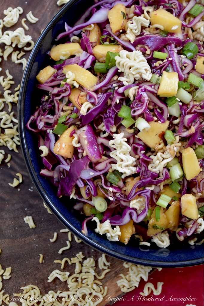 Fresh Peach & Ramen Noodle Red Cabbage Slaw - This vibrant slaw marries the satisfying crunch of crisp red cabbage with the mellow sweetness of juicy, ripe peaches. An unexpectedly perfect match. Fresh chopped scallions and aromatic basil add a pop of color and flavor, while an easy-to-make soy dressing ties everything together. But the real game-changer? The generous addition of toasted sesame seeds and crispy ramen noodles ensures that each bite delivers an irresistible burst of crunchy texture. Light, flavorful, and incredibly refreshing, this side dish is exactly what your hot summer day has been craving.