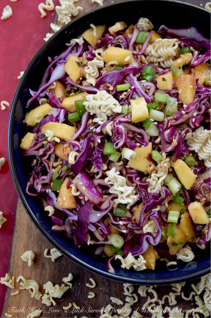 Fresh Peach & Ramen Noodle Red Cabbage Slaw - This vibrant slaw marries the satisfying crunch of crisp red cabbage with the mellow sweetness of juicy, ripe peaches. An unexpectedly perfect match. Fresh chopped scallions and aromatic basil add a pop of color and flavor, while an easy-to-make soy dressing ties everything together. But the real game-changer? The generous addition of toasted sesame seeds and crispy ramen noodles ensures that each bite delivers an irresistible burst of crunchy texture. Light, flavorful, and incredibly refreshing, this side dish is exactly what your hot summer day has been craving.