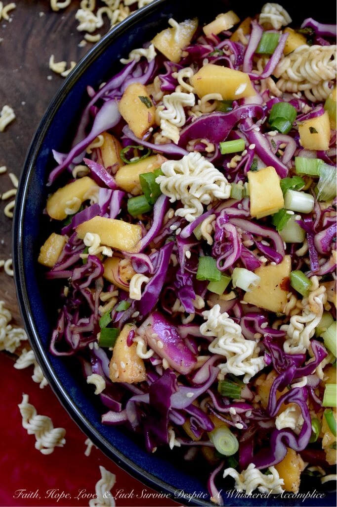 Fresh Peach & Ramen Noodle Red Cabbage Slaw - This vibrant slaw marries the satisfying crunch of crisp red cabbage with the mellow sweetness of juicy, ripe peaches. An unexpectedly perfect match. Fresh chopped scallions and aromatic basil add a pop of color and flavor, while an easy-to-make soy dressing ties everything together. But the real game-changer? The generous addition of toasted sesame seeds and crispy ramen noodles ensures that each bite delivers an irresistible burst of crunchy texture. Light, flavorful, and incredibly refreshing, this side dish is exactly what your hot summer day has been craving.