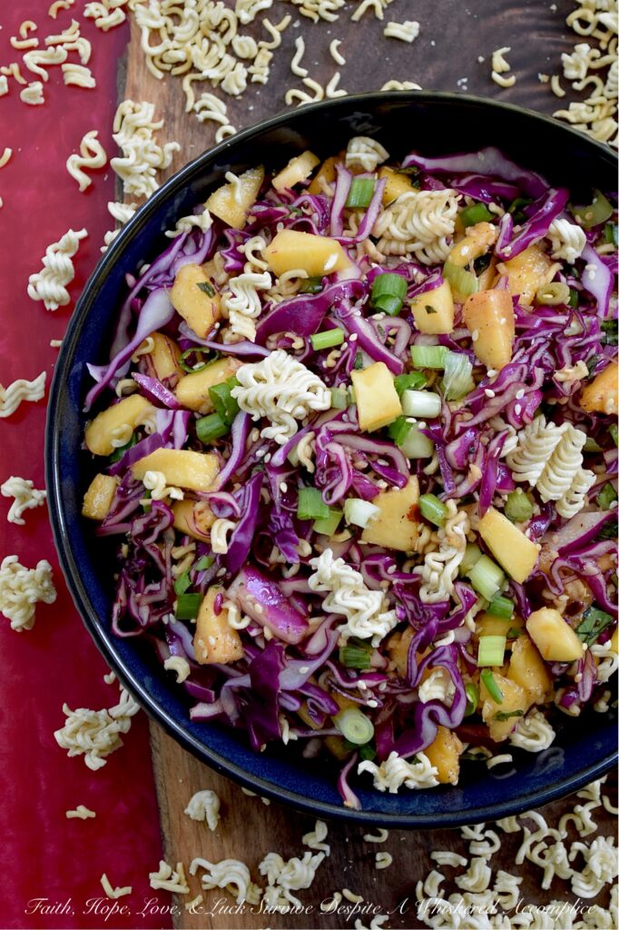 Fresh Peach & Ramen Noodle Red Cabbage Slaw - This vibrant slaw marries the satisfying crunch of crisp red cabbage with the mellow sweetness of juicy, ripe peaches. An unexpectedly perfect match. Fresh chopped scallions and aromatic basil add a pop of color and flavor, while an easy-to-make soy dressing ties everything together. But the real game-changer? The generous addition of toasted sesame seeds and crispy ramen noodles ensures that each bite delivers an irresistible burst of crunchy texture. Light, flavorful, and incredibly refreshing, this side dish is exactly what your hot summer day has been craving.