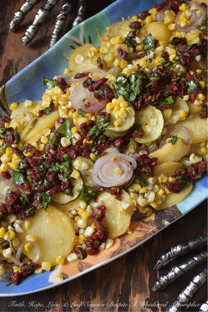 Sheet Pan Italian Olive Oil Summer Vegetables - Imagine thinly sliced potatoes, sweet onions, and tender zucchini mingling with bright corn kernels, all lightly coated with olive oil, salt, and pepper, then baked to tender, moist perfection. Once slightly cooled, these fresh summer vegetables are topped with a delicious Italian-inspired dressing made of bright olive oil, tangy balsamic vinegar, savory sun-dried tomatoes, and fragrant fresh basil. This healthy sheet pan bake demonstrates how simple ingredients, when thoughtfully combined, can create big, memorable flavors and an elegant presentation that will leave everyone eager to dig in.