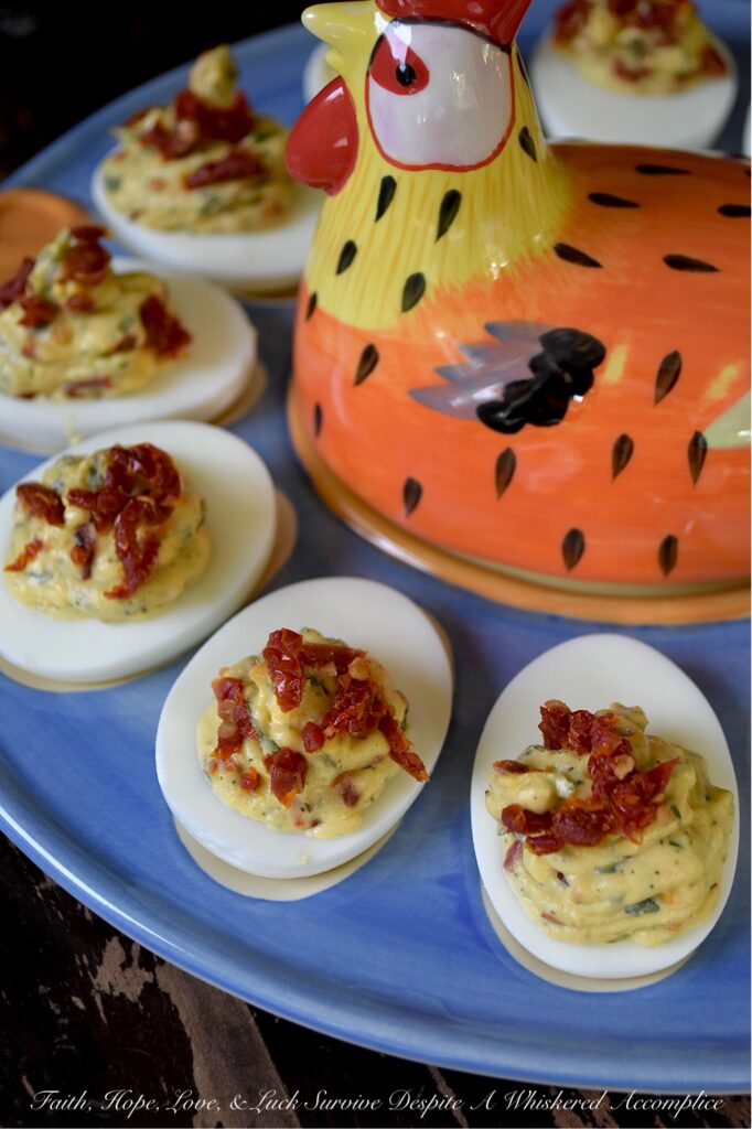 Chunky Sun-Dried Tomato & Basil Deviled Eggs - I think we can all agree that not every deviled egg is a showstopper. But these chunky sun-dried tomato and fresh basil deviled eggs? They’re the kind of appetizer that makes people pause mid-bite, look at you with wide eyes, and demand to know what magic you’ve tucked inside. With a rich, creamy yolk filling studded with chewy, intensely sweet sun-dried tomatoes and flecked with fresh, fragrant basil, these little appetizer gems are perfect for any occasion that calls for a truly standout bite. One thing is for sure, no matter when you serve them, these Italian-style deviled eggs are guaranteed to disappear quickly.