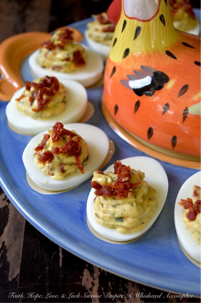 Chunky Sun-Dried Tomato & Basil Deviled Eggs - I think we can all agree that not every deviled egg is a showstopper. But these chunky sun-dried tomato and fresh basil deviled eggs? They’re the kind of appetizer that makes people pause mid-bite, look at you with wide eyes, and demand to know what magic you’ve tucked inside. With a rich, creamy yolk filling studded with chewy, intensely sweet sun-dried tomatoes and flecked with fresh, fragrant basil, these little appetizer gems are perfect for any occasion that calls for a truly standout bite. One thing is for sure, no matter when you serve them, these Italian-style deviled eggs are guaranteed to disappear quickly.