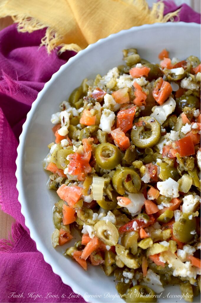 Mild Green Olive Salad Muffuletta Spread - Of course, this green olive salad is the classic go-to for muffuletta sandwiches, but it’s just as irresistible piled onto a hot, cheesy pizza, creamy deviled eggs, or simply scooped up or spread on a hunk of crusty bread. With buttery-soft green, ripe, pitted olives, mild giardiniera, and capers all mingling together in a simple red wine vinaigrette, you get a burst of flavor that’s big on taste but not on heat. Basically, this is the kind of condiment you’ll want to slather on just about every sandwich you make from here on out.