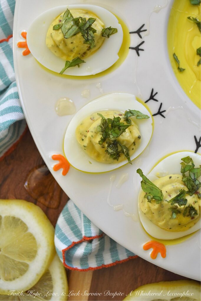 Whipped Feta Lemon Zest & Basil Deviled Eggs - These sophisticated deviled eggs are filled with a creamy whipped feta dip made with salty feta, smooth cream cheese, lemon zest, fresh basil, and a hint of honey. With a touch of whole grain mustard, crushed red pepper flakes, and even more fresh basil for added flavor, these deviled eggs are bright, creamy, and perfect for when you need an elegant appetizer to steal the show. A final drizzle of honey and a sprinkle of fresh basil really help make them as gorgeous as they are delicious. And since you'll only use 3/4 cup of the whipped feta for this recipe, you'll have plenty left over to enjoy as a snack with pita bread, pretzels, or pita crackers.