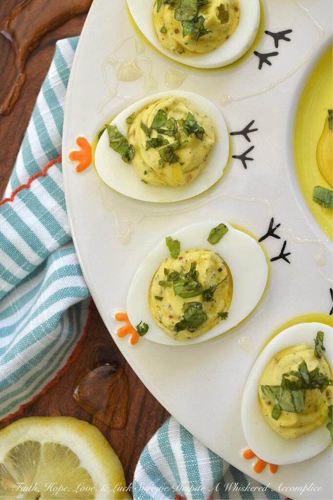Whipped Feta Lemon Zest & Basil Deviled Eggs - These sophisticated deviled eggs are filled with a creamy whipped feta dip made with salty feta, smooth cream cheese, lemon zest, fresh basil, and a hint of honey. With a touch of whole grain mustard, crushed red pepper flakes, and even more fresh basil for added flavor, these deviled eggs are bright, creamy, and perfect for when you need an elegant appetizer to steal the show. A final drizzle of honey and a sprinkle of fresh basil really help make them as gorgeous as they are delicious. And since you'll only use 3/4 cup of the whipped feta for this recipe, you'll have plenty left over to enjoy as a snack with pita bread, pretzels, or pita crackers.