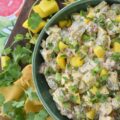 Creamy Cilantro Herb Caribbean Potato Salad - Tired of the same boring traditional potato salad? Bring a little tropical flavor to your next picnic or barbecue with this creamy Caribbean version, featuring jerk seasoning, diced pimentos, and fresh mango. This flavorful herby potato salad has a touch of heat and is just a little bit sweet. With cilantro, scallions, and a splash of vinegar to brighten things up, this island-inspired recipe turns a bag of small yellow potatoes into a side dish that will have everyone practically begging you for the recipe.
