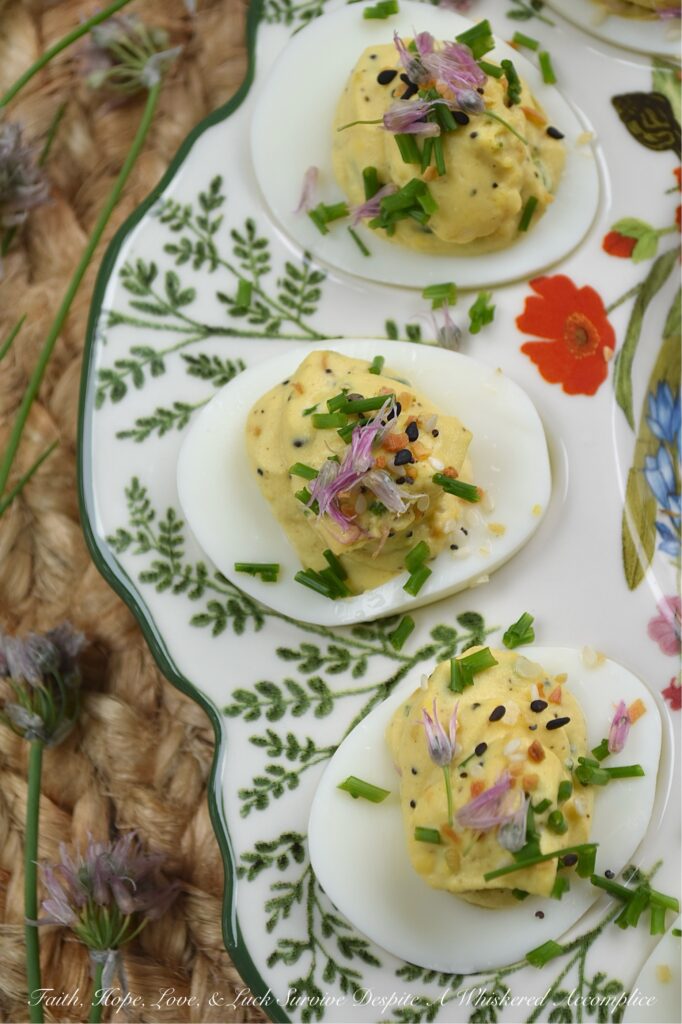 Everything Bagel Chive Blossom Deviled Eggs - From May to June, chive blossoms make their annual appearance, and if you aren't eating the flowers, you're missing out on the best secret in your late spring to early summer garden. These edible flowers offer a subtle, sweet, sophisticated onion flavor that pairs perfectly with the rich, creamy filling of a deviled egg. With everything bagel seasoning, finely chopped fresh chives, and chive florets, this recipe hits that perfect balance of crunch, creaminess, and garden-fresh flavor. Fresh, sophisticated, and undeniably gorgeous, these deviled eggs are a must-make while the chive blossom blooms are still in their prime.