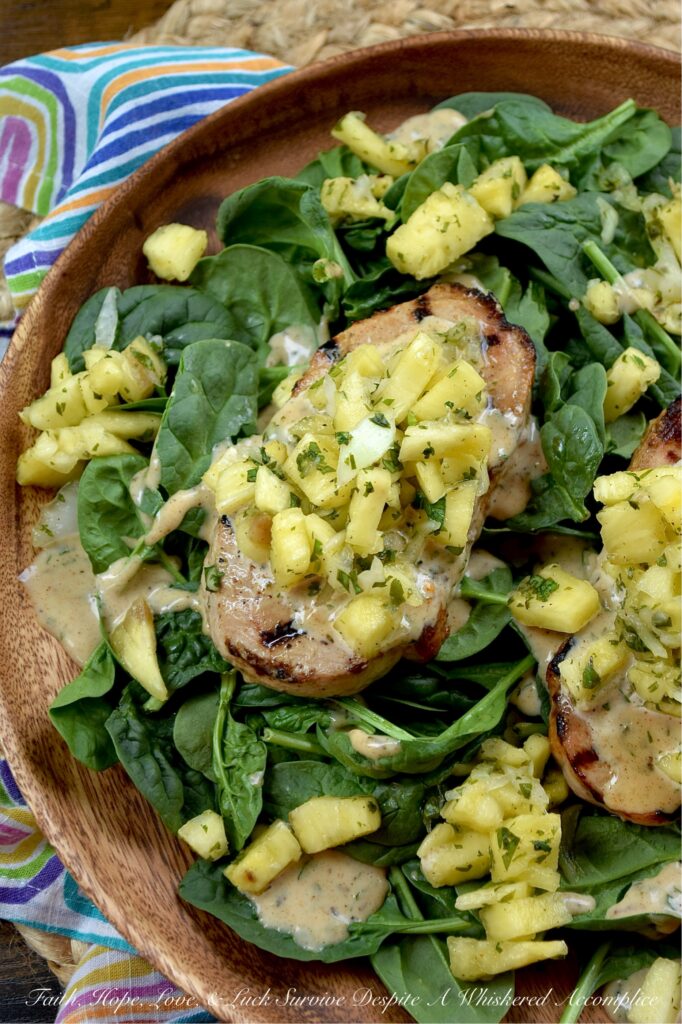 Caribbean Pineapple & Honey Mustard Pork Chops - While most of us aren’t lucky enough to be lounging on a beach in the Caribbean, we can certainly bring the spirit of the islands straight to our dinner table with these sweet and spicy grilled pork chops. The secret is an easy-to-make homemade jerk seasoning blend used to season both sides of each pork chop before grilling. That same seasoning mix is also used to make a simple honey mustard sauce and a quick pineapple sweet yellow onion salsa, both of which top each seared pork chop. Served over a crisp bed of baby spinach, this is the ultimate summer meal. Light, refreshing, and guaranteed to make your summer dinner feel like a getaway.