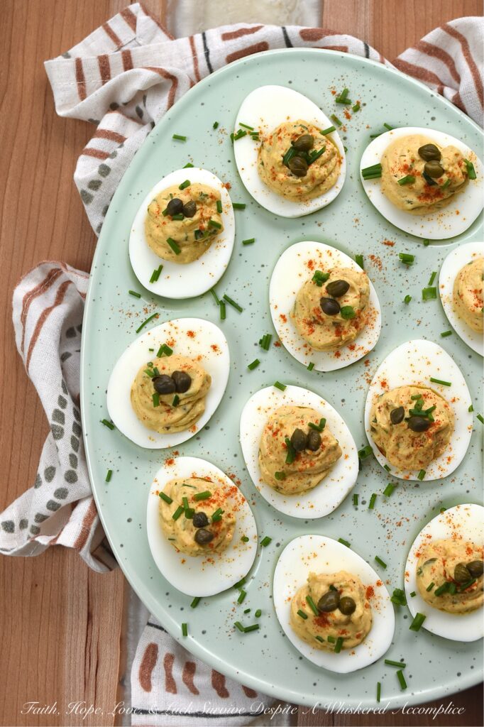 Deviled Eggs with Lemon Caper Remoulade - These flavorful deviled eggs take things to the next level with a zesty, homemade lemon caper remoulade. With a bright punch of lemon zest and the perfect salty bite of capers, these appetizer cuties are about to become the star of every backyard barbecue. And, thanks to a touch of heat, these deviled eggs are anything but ordinary. Finished with a dusting of paprika, a garden-fresh garnish of chives, and a few whole non-pareil capers, these lil' bites are guaranteed to disappear practically the moment you set them down.