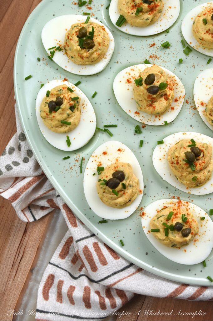 Deviled Eggs with Lemon Caper Remoulade - These flavorful deviled eggs take things to the next level with a zesty, homemade lemon caper remoulade. With a bright punch of lemon zest and the perfect salty bite of capers, these appetizer cuties are about to become the star of every backyard barbecue. And, thanks to a touch of heat, these deviled eggs are anything but ordinary. Finished with a dusting of paprika, a garden-fresh garnish of chives, and a few whole non-pareil capers, these lil' bites are guaranteed to disappear practically the moment you set them down.