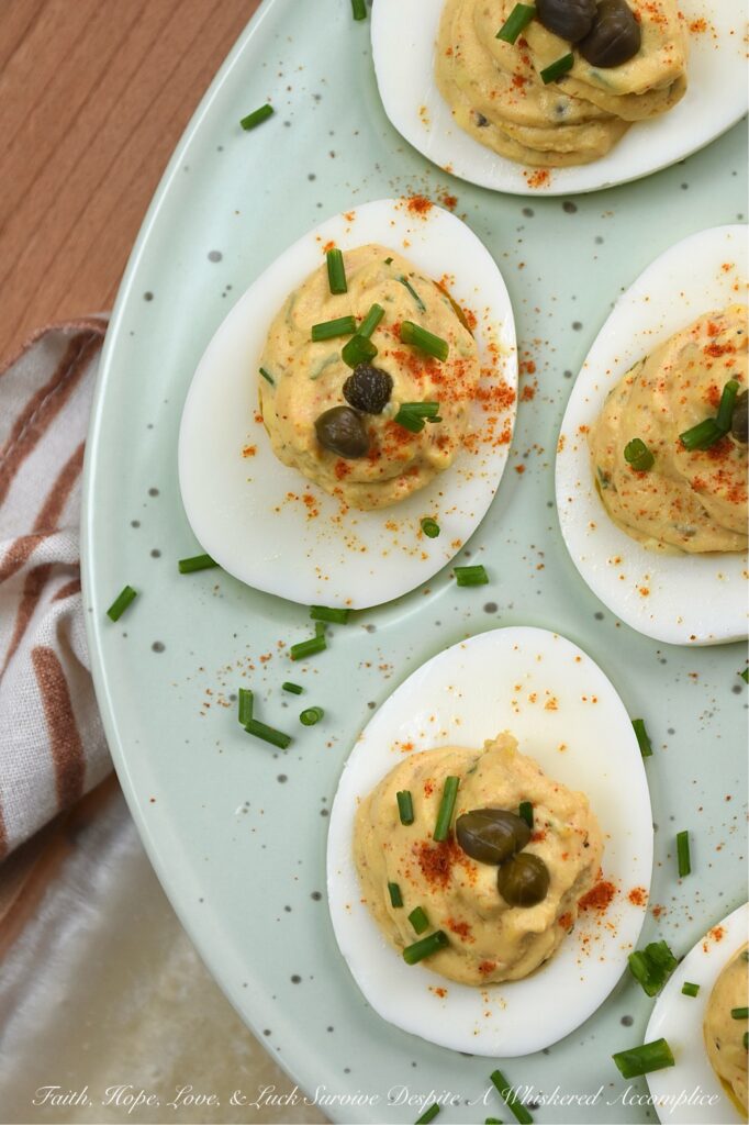 Deviled Eggs with Lemon Caper Remoulade - These flavorful deviled eggs take things to the next level with a zesty, homemade lemon caper remoulade. With a bright punch of lemon zest and the perfect salty bite of capers, these appetizer cuties are about to become the star of every backyard barbecue. And, thanks to a touch of heat, these deviled eggs are anything but ordinary. Finished with a dusting of paprika, a garden-fresh garnish of chives, and a few whole non-pareil capers, these lil' bites are guaranteed to disappear practically the moment you set them down.