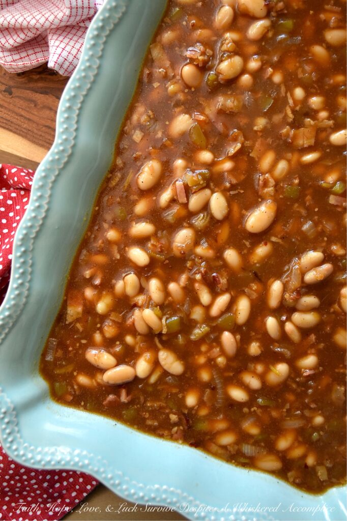 Smoky Baked Beans with Green Chiles & Bacon - Most store-bought baked beans are overly sweet, mushy, and entirely forgettable. This recipe, however, uses canned Great Northern Beans. Elevating them with a quick and easy homemade sauce. Between the smoky bacon, the subtle heat of green chiles, and the deep, wood-fired flavor from a generous splash of liquid smoke, these beans are practically addictive. They're thick, sticky, smoky, and best of all? You can prep them days in advance, making this side dish the perfect stress-free secret weapon for your next backyard barbecue or picnic.