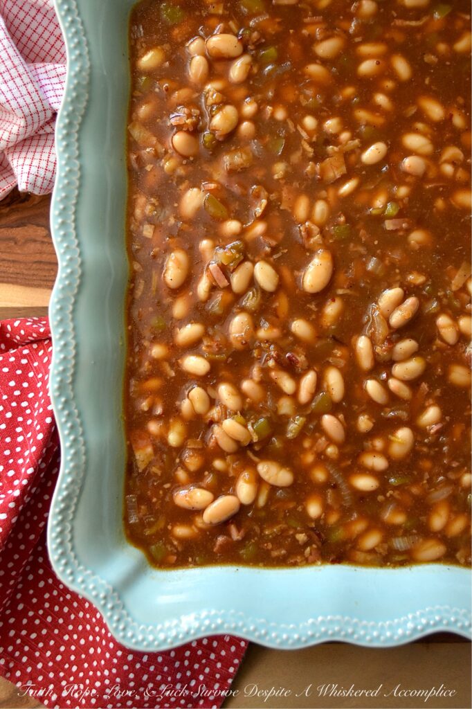 Smoky Baked Beans with Green Chiles & Bacon - Most store-bought baked beans are overly sweet, mushy, and entirely forgettable. This recipe, however, uses canned Great Northern Beans. Elevating them with a quick and easy homemade sauce. Between the smoky bacon, the subtle heat of green chiles, and the deep, wood-fired flavor from a generous splash of liquid smoke, these beans are practically addictive. They're thick, sticky, smoky, and best of all? You can prep them days in advance, making this side dish the perfect stress-free secret weapon for your next backyard barbecue or picnic.