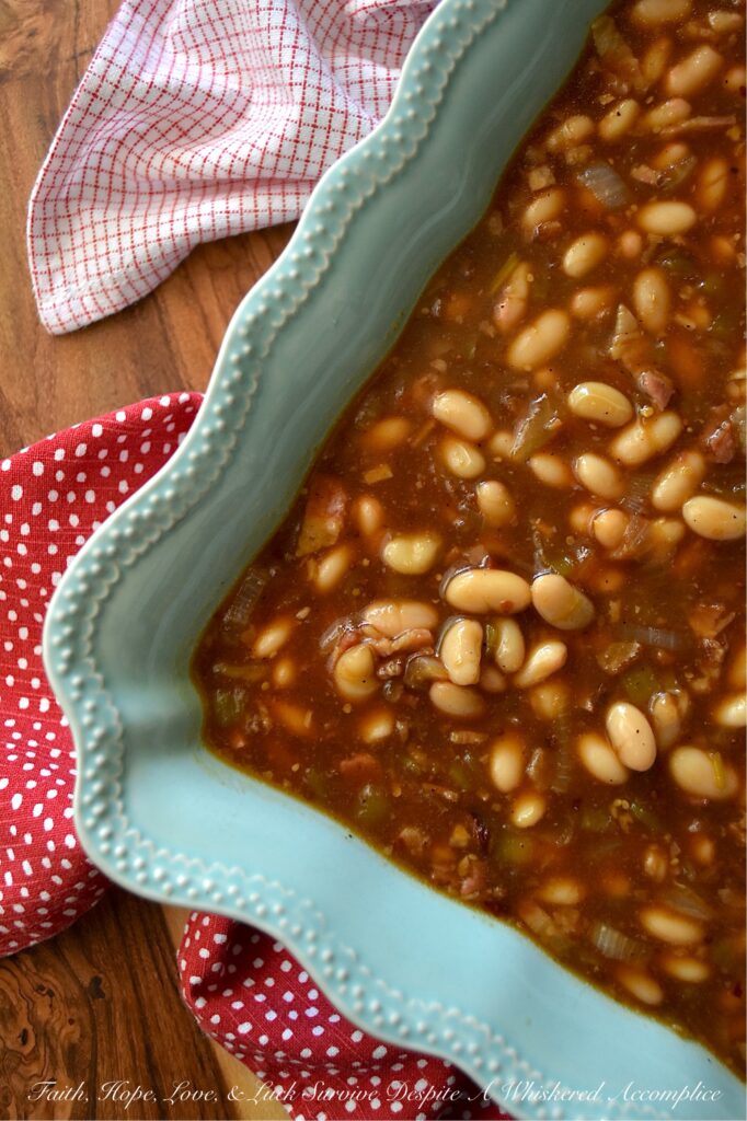 Smoky Baked Beans with Green Chiles & Bacon - Most store-bought baked beans are overly sweet, mushy, and entirely forgettable. This recipe, however, uses canned Great Northern Beans. Elevating them with a quick and easy homemade sauce. Between the smoky bacon, the subtle heat of green chiles, and the deep, wood-fired flavor from a generous splash of liquid smoke, these beans are practically addictive. They're thick, sticky, smoky, and best of all? You can prep them days in advance, making this side dish the perfect stress-free secret weapon for your next backyard barbecue or picnic.