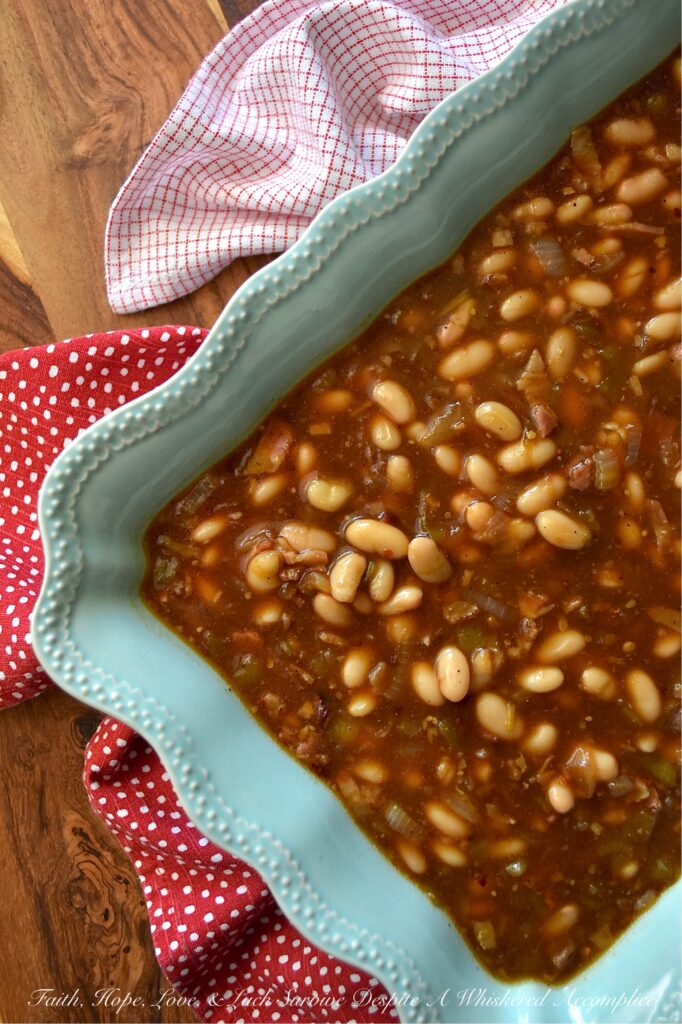 Smoky Baked Beans with Green Chiles & Bacon - Most store-bought baked beans are overly sweet, mushy, and entirely forgettable. This recipe, however, uses canned Great Northern Beans. Elevating them with a quick and easy homemade sauce. Between the smoky bacon, the subtle heat of green chiles, and the deep, wood-fired flavor from a generous splash of liquid smoke, these beans are practically addictive. They're thick, sticky, smoky, and best of all? You can prep them days in advance, making this side dish the perfect stress-free secret weapon for your next backyard barbecue or picnic.