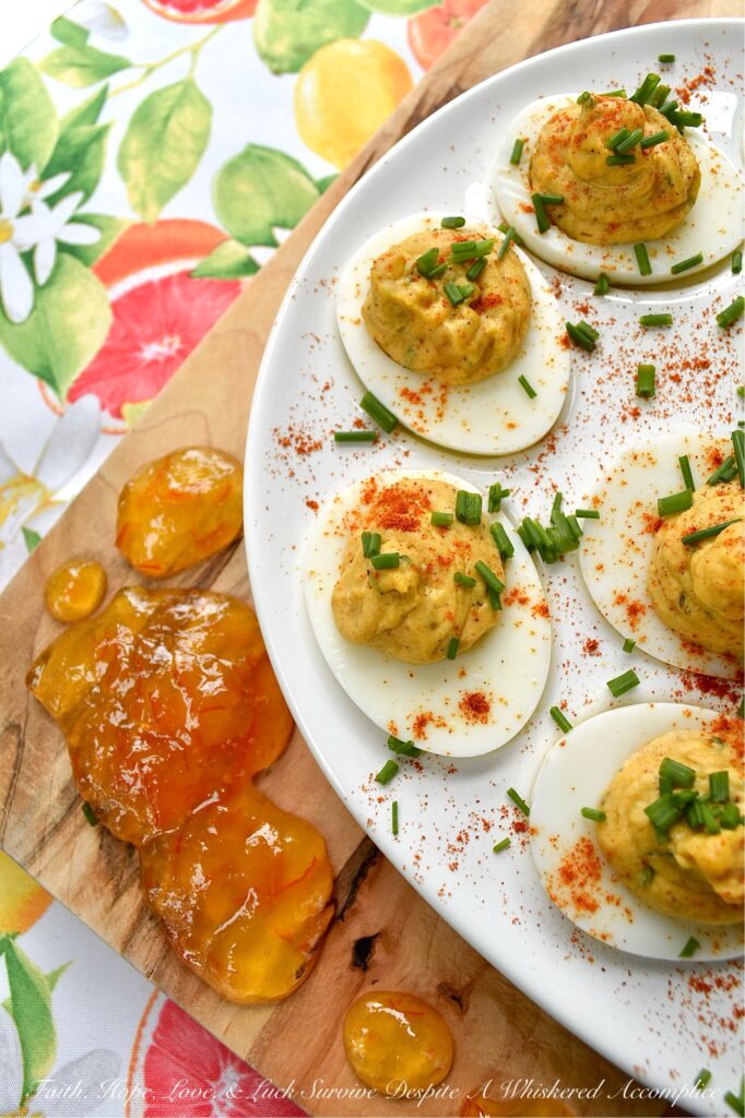 Jerk Seasoned Caribbean Marmalade Deviled Eggs - These jerk-seasoned deviled eggs pack a serious island punch, blending the smoky heat of homemade jerk seasoning with the unexpected, bright, and bitter sweetness of orange marmalade. They’re creamy, deeply spiced, and just plain ol' gorgeous on a deviled egg platter. Topped with a vibrant pop of fresh chives and a dusting of paprika, these Caribbean beauties bring a taste of the islands directly to your kitchen table with no plane ticket required.