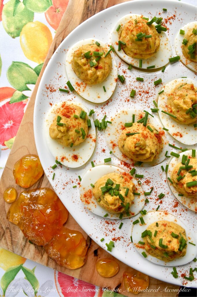 Jerk Seasoned Caribbean Marmalade Deviled Eggs - These jerk-seasoned deviled eggs pack a serious island punch, blending the smoky heat of homemade jerk seasoning with the unexpected, bright, and bitter sweetness of orange marmalade. They’re creamy, deeply spiced, and just plain ol' gorgeous on a deviled egg platter. Topped with a vibrant pop of fresh chives and a dusting of paprika, these Caribbean beauties bring a taste of the islands directly to your kitchen table with no plane ticket required.