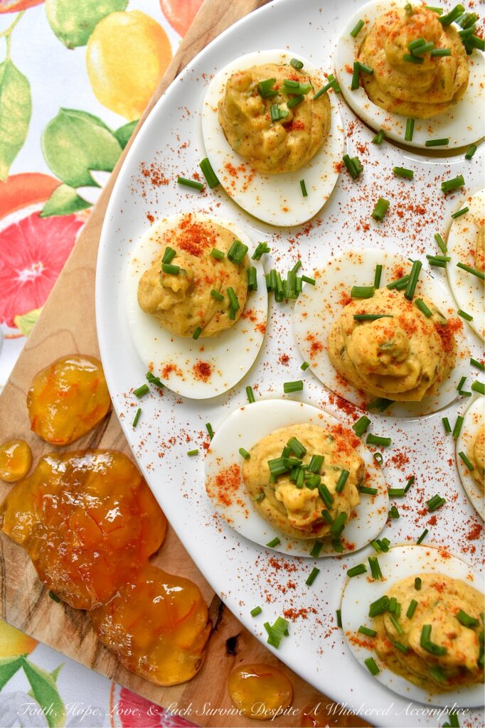 Jerk Seasoned Caribbean Marmalade Deviled Eggs - These jerk-seasoned deviled eggs pack a serious island punch, blending the smoky heat of homemade jerk seasoning with the unexpected, bright, and bitter sweetness of orange marmalade. They’re creamy, deeply spiced, and just plain ol' gorgeous on a deviled egg platter. Topped with a vibrant pop of fresh chives and a dusting of paprika, these Caribbean beauties bring a taste of the islands directly to your kitchen table with no plane ticket required.